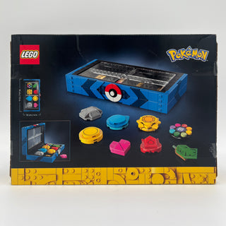 LEGO Pokémon set box showing blue storage container with Poké Ball design and colorful badge pieces displayed.