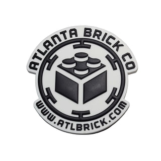Round silver and black magnet with Atlanta Brick Co logo featuring a brick block in the center and website text.