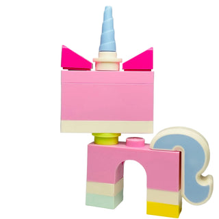 Colorful brick-built unicorn figure with blue horn, pink ears, and pastel body blocks in pink, cream, yellow, and green.