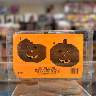 LEGO polybag package with orange label featuring two brown brick-built jack-o'-lantern pumpkin faces with carved expressions.