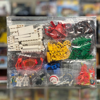 LEGO set 6494 contents organized in clear compartments including tan bricks, red and black pieces, yellow connectors, green p