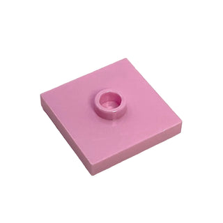 Pink square plate with central stud and groove detail.