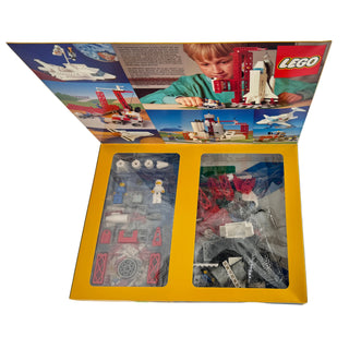 LEGO Town Space Shuttle set box open showing minifigures, brick parts, and assembly components inside.