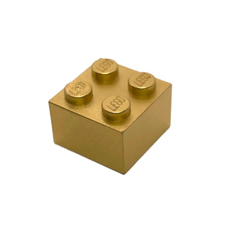 Gold-colored plastic brick with four studs arranged in a 2x2 pattern and LEGO branding on studs.
