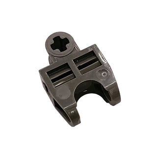 Dark gray plastic connector with ball joint socket on top, two angled open-sided forks below, and closed axle holes.