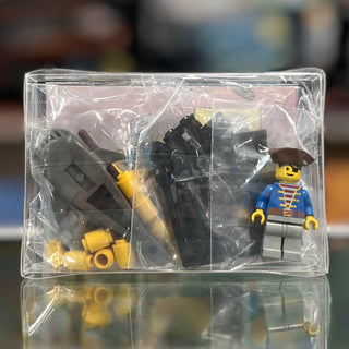 Clear plastic box containing LEGO pirate minifigure, black boat pieces, and yellow accessories.