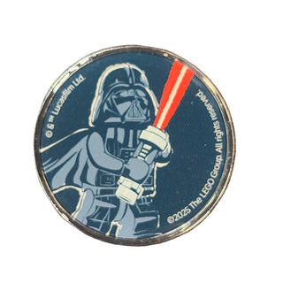 Round metal coin featuring Lego Darth Vader holding a red lightsaber on dark blue background.