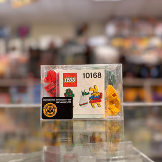 LEGO set 10168 polybag in clear plastic container with instruction booklet and red and yellow brick pieces visible.