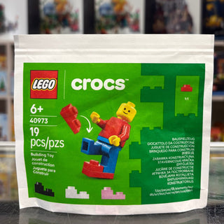 LEGO Crocs white paper bag featuring green background with red LEGO logo, product number 40973, and colorful brick minifigure