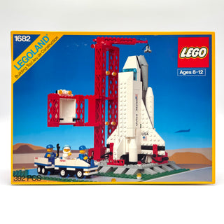 LEGO Space Shuttle set 1682 with white and red shuttle, red launch tower, vehicle, and minifigures on desert landscape.
