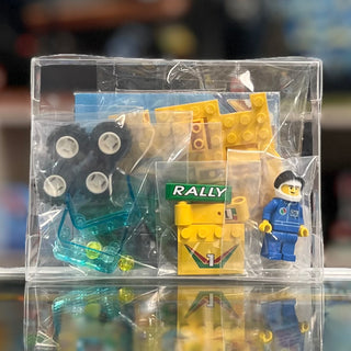 Yellow and blue LEGO rally car set in clear plastic packaging with minifigure and wheel components visible.
