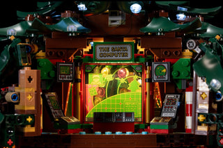 Illuminated LEGO Christmas tree display featuring "The Santa Computer" arcade game with colorful LED lights on green, brown, 