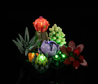 Illuminated LEGO succulents in red, purple, green, and yellow with glowing LED lights throughout each plant piece.