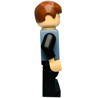 LEGO minifigure with brown hair, tan face, sand blue vest with black hand detail, and black legs.