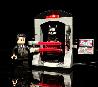 LEGO Batman set with illuminated Batsuit display case, Bruce Wayne minifigure in suit, and control panel with red lighting el