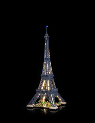 LEGO Eiffel Tower model with warm white and green interior lighting installed throughout the structure and base.