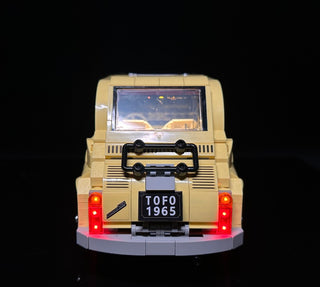 Cream-colored LEGO Fiat 500 with illuminated red tail lights and undercarriage glow on display base.