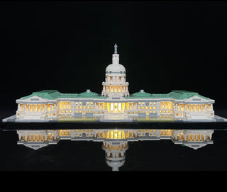 LEGO Capitol Building model with illuminated windows and dome, displayed with reflection on black base.
