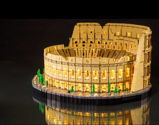 Illuminated tan LEGO Colosseum model with warm white and green LED lights throughout the structure on black base.