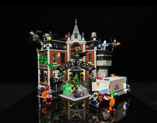 Illuminated LEGO Arkham Asylum set featuring brick building with glowing green and yellow lights, minifigures, and detailed e