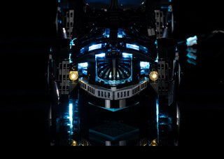 Black LEGO Batmobile with blue and white LED lighting installed throughout the vehicle and yellow headlights.