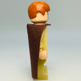 LEGO minifigure with orange hair, tan face, brown textured robe, and yellow tunic.