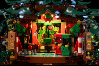 Illuminated LEGO Christmas tree decoration with multicolored LED lights on green, red, and brown brick structure.