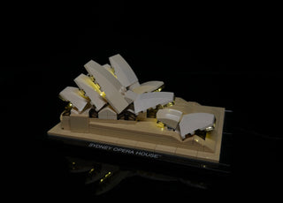 LEGO Sydney Opera House set with illuminated shell structures showing warm white LED lights underneath.