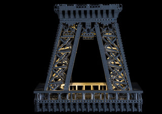 LEGO Eiffel Tower set with warm white LED lights illuminating the structure and interior framework.