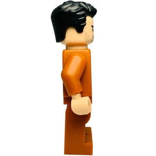 Minifigure with black hair, tan face, and orange jumpsuit with tan hands and feet.