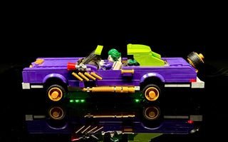 Purple LEGO lowrider car with illuminated green undercarriage lights, yellow accents, and glowing wheel rims against black ba