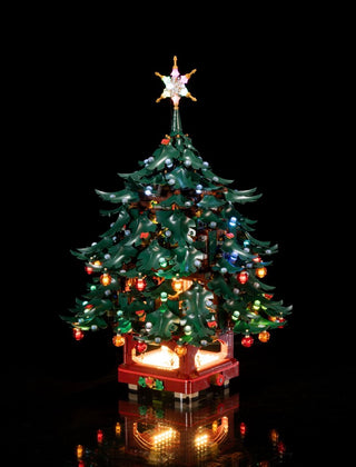 LEGO Christmas tree with illuminated star topper, colorful lights throughout green branches, and glowing red base on black ba