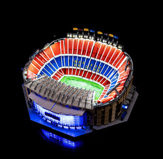 LEGO Camp Nou stadium model with illuminated seating sections in red and blue, green field, and lit exterior details.