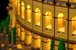 LEGO Colosseum architecture with warm yellow LED lighting illuminating arched windows and columns.