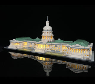 Capitol Building LEGO set with illuminated windows and dome, displayed on black base with green roof details.