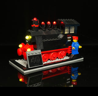 LEGO train set with illuminated red and yellow lights on locomotive and passenger cars, includes minifigure.