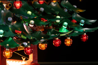 LEGO Christmas tree with multicolored LED lights including red, green, blue, and warm white bulbs on green branches.
