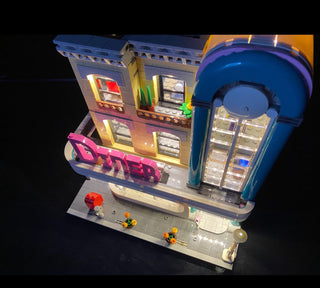 LEGO Downtown Diner set with custom lighting installed in windows, signage, and interior sections.