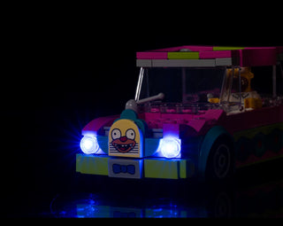 LEGO Krusty Burger food truck with illuminated blue headlights and undercarriage lighting against dark background.