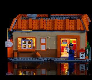 LEGO Krusty Burger building set illuminated with warm LED lights in windows and interior sections.