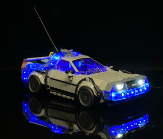 Tan and gray LEGO Time Machine car with blue LED lights illuminated throughout the body and headlights.