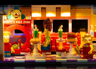 Illuminated LEGO Krusty Burger restaurant set with lit signage, glowing interior panels, and character minifigures displayed 