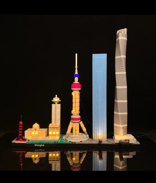 LEGO Shanghai skyline architecture set with illuminated buildings including pagoda, tower, and skyscraper on black display ba