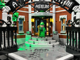 LEGO Arkham Asylum set 76300 with green LED lighting installed on building entrance, minifigure, and architectural details.
