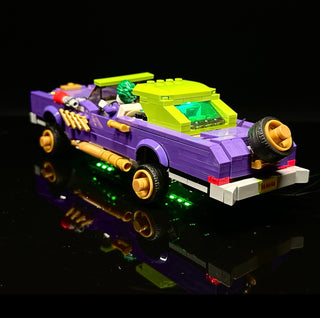 Purple and yellow LEGO lowrider car with illuminated gold wheels, green undercarriage lights, and yellow roof section against