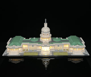 LEGO Capitol Building set with warm white LED lights illuminating the dome, wings, and windows against a black background.