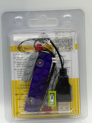 Custom lighting kit containing purple LED brick, gray connector piece, wired components, and USB power cable in clear packagi