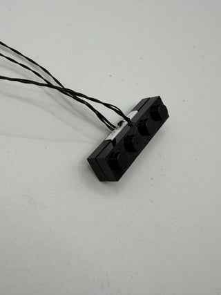 Black vertical power connector block with six socket ports and attached black wires.