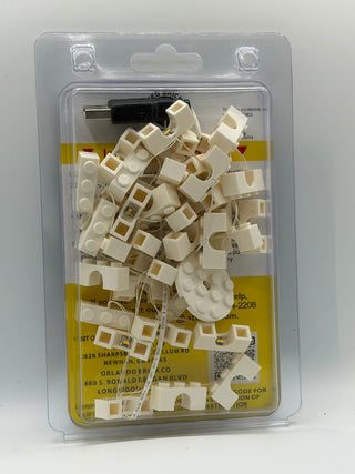 Custom LED lighting kit with cream-colored brick connectors, wiring, and black power adapter in clear plastic clamshell packa