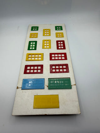 Vintage card set displaying colored plastic window and door pieces in green, yellow, red, blue, and dark green on cream-color